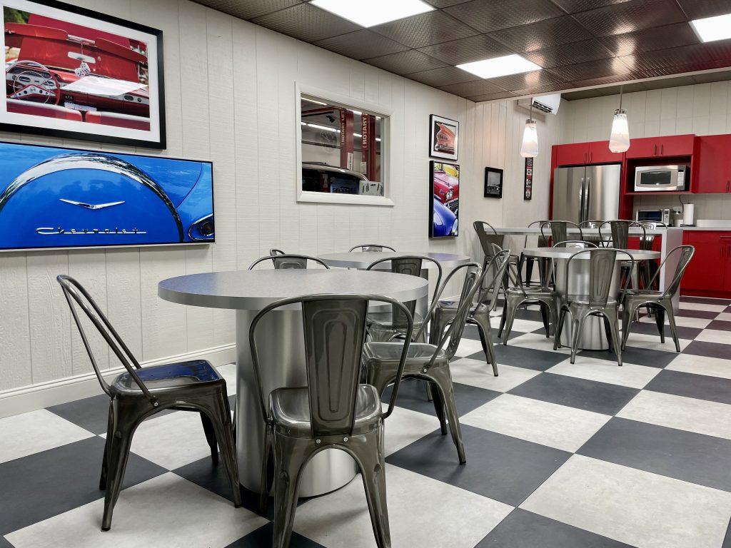 Red retro kitchen with black and white checkered floor and chrome dining table by Design House Interiors